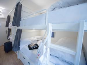 two bunk beds in a dorm room with a suitcase at room00 Lisboa Hostel in Lisbon