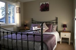 um quarto com uma cama com lençóis roxos e uma janela em Golden Cross Holiday Park em Hailsham