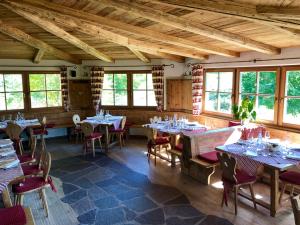 a dining room with tables and chairs and windows at Agriturismo Maso Corradini in Castello di Fiemme