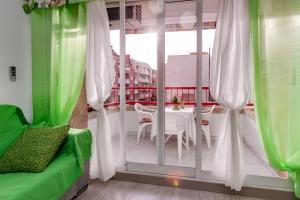 Cette chambre dispose d'un balcon avec une table et une fenêtre. dans l'établissement Apartment Studio Playa del Cura, à Torrevieja