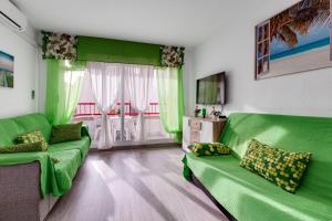 un salon vert avec deux canapés verts et une télévision dans l'établissement Apartment Studio Playa del Cura, à Torrevieja