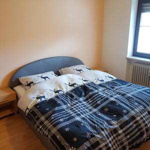 un letto in una camera da letto con piumone blu e bianco di Haus Hochgrat a Oberstaufen