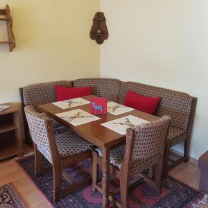 a dining room table with chairs and red pillows at Haus Hochgrat in Oberstaufen