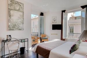 a bedroom with two beds and a table and chairs at Hotel Select in Beaulieu-sur-Mer