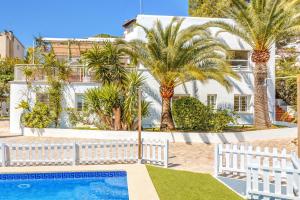 a white house with palm trees and a swimming pool at Villa Bellver in Palma de Mallorca