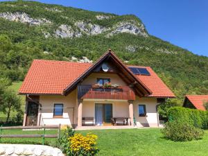 a house with a mountain in the background at Apartmaji BOHINJ in Bohinj