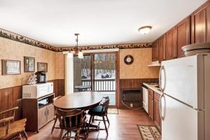 a kitchen with a table and a refrigerator at Cleerwood Village #252 in Eagle River