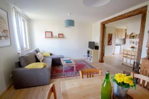 una sala de estar con un sofá y una mesa en Le Gîte du Moulin, en Ribeauvillé