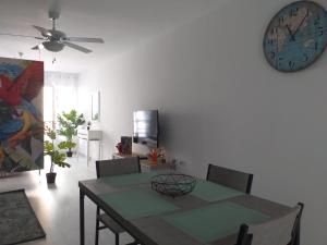 a dining room with a table and a clock on the wall at Tropical Loft in Corralejo