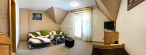 a living room with a couch and a tv at Apartmaji BOHINJ in Bohinj