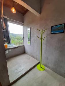 une chambre avec un poteau vert dans l'angle d'une pièce dans l'établissement Suítes The Search Ubatuba Surf - Maranduba, à Ubatuba
