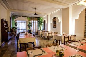 a restaurant with tables and chairs in a room at Hotel Villarosa con Vespa Rent in Sarroch