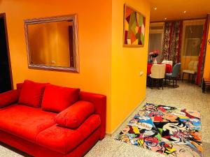 a living room with a red couch and a rug at Party House in Cielavas