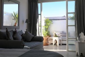 uma sala de estar com um sofá e uma porta de vidro deslizante em Dar Seven em Marraquexe