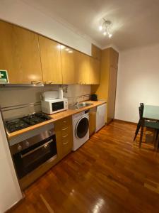 a kitchen with a stove and a microwave at Prime Location - Historic District with Private Parking in Lisbon