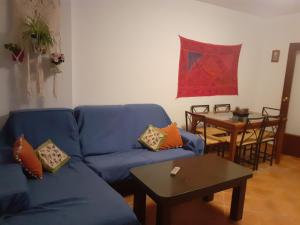 a living room with a blue couch and a table at Apartamento El Portiel in Gotor