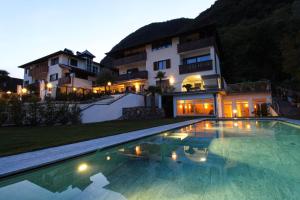 une grande piscine en face d'une maison dans l'établissement Hotel Römerrast, à Caldaro