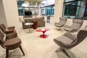 uma sala de espera com cadeiras e uma mesa vermelha em Life Hotel Torres em Torres