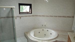 a bathroom with a bath tub and a window at Mansão Adonai nas Cachoeiras de Penedo in Penedo +52 photos