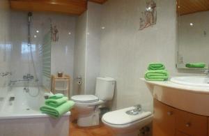 y baño con aseo, lavabo y bañera. en Casa Antonia en Vilaller