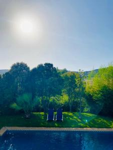 2 sillas azules sentadas junto a una piscina en Casa Cantarrana, en Arriate