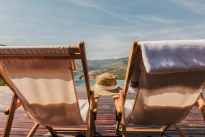 two chairs and a hat sitting on a wooden deck at Ventozelo Hotel & Quinta in Ervedosa do Douro