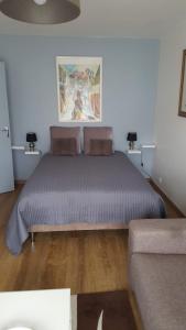 een slaapkamer met een groot bed en een bank bij Chez marilyn in Deauville