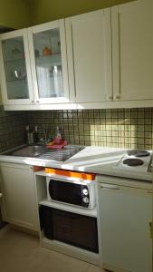 a kitchen with white cabinets and a sink and a stove at Chez marilyn in Deauville