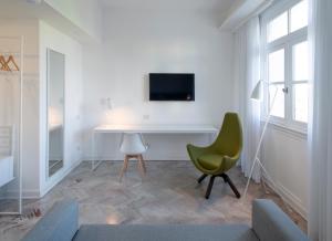 ein Wohnzimmer mit einem Schreibtisch und einem grünen Stuhl in der Unterkunft Palacio Paz Boutique Hotel in Buenos Aires