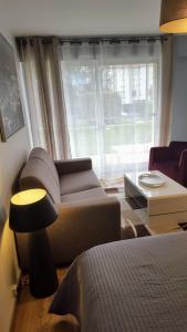 uma sala de estar com um sofá e uma janela em Chez marilyn em Deauville