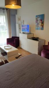 a bedroom with a bed and a tv and chairs at Chez marilyn in Deauville