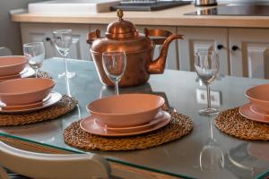 een tafel met een waterkoker en borden en glazen bij La Casita de Candela Toledo in Toledo