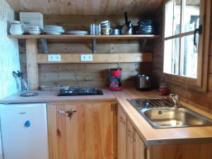 a kitchen with a sink and a counter top at Le Chalet du Clos Giot in Saint-Vaast-la-Hougue