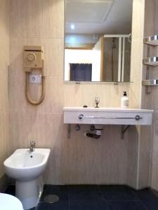 a bathroom with a sink and a toilet and a mirror at Apartamentos Monte Gorbea con parking y WiFi by SURYNIEVE in Sierra Nevada +19 photos
