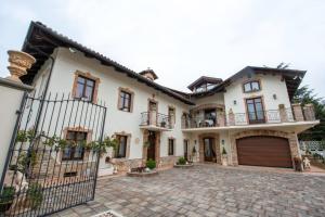 uma grande casa branca com uma entrada em Cà Reginella B&B em Diano dʼAlba