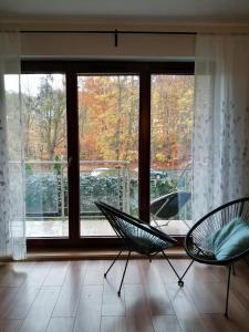 a room with two chairs in front of a window at Apartament Pohulanka in Gdańsk