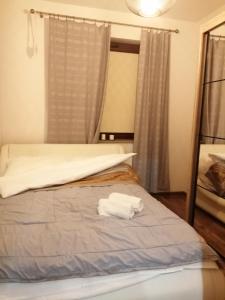 a bedroom with a bed with a white towel on it at Apartament Pohulanka in Gdańsk