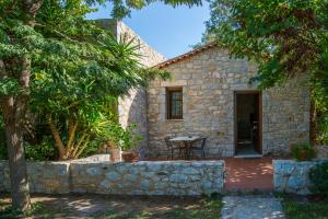 a stone house with a table in front of it at Ktima Petalea in Gythio