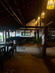 uma sala de jantar com mesas e candeeiros num edifício em Pousada Maraú em Marau