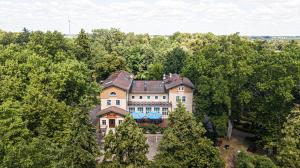 an overhead view of a large house in the trees at Dworek Brodowo Restauracja Hotel Przyjęcia in Brodowo