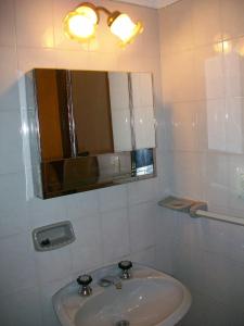a white bathroom with a sink and a mirror at Hosteria Columbia in Mina Clavero