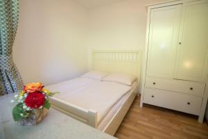 a small bedroom with a bed with a vase of flowers at Ferienwohnung Nicole in Missen-Wilhams