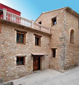 un gran edificio de ladrillo con un balcón en la parte superior. en Hotel Rural Barranc De L'ínfern en Vall de Ebo