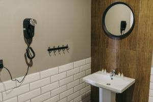 ein Badezimmer mit einem Waschbecken und einem Telefon an der Wand in der Unterkunft Гостиница ИВАНОВООТЕЛЬ in Iwanowo