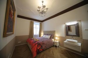 a bedroom with a bed and a sink and a chandelier at Vitez Apartment I in Ljubljana