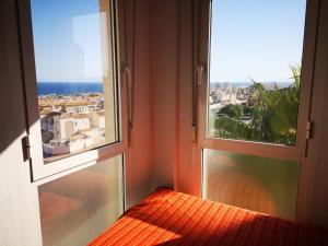 a room with two windows with a view of the ocean at Alta Vista - apartamento con 2 dormitorios y vista al mar in Torrevieja