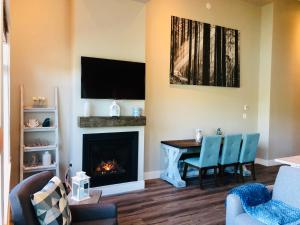 a living room with a table and a fireplace at Sandy Feet Retreat Port Renfrew- Oceanfront 2BR modern cottage in Port Renfrew
