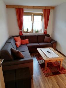 uma sala de estar com um sofá e uma mesa em Apart Waldesruh em Arzl im Pitztal