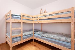 two bunk beds in a room with wooden floors at Alpine Home Apartment in Bohinj