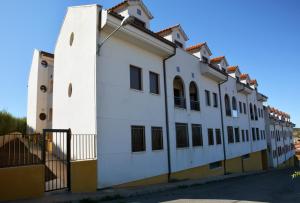 a white building with a clock tower next to a street at Apartamento Azero 22 in Ruidera